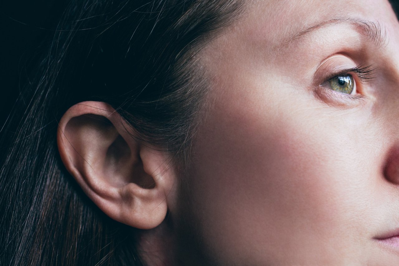 Close-up of a woman’s ear and eye, illustrating hearing health and awareness.