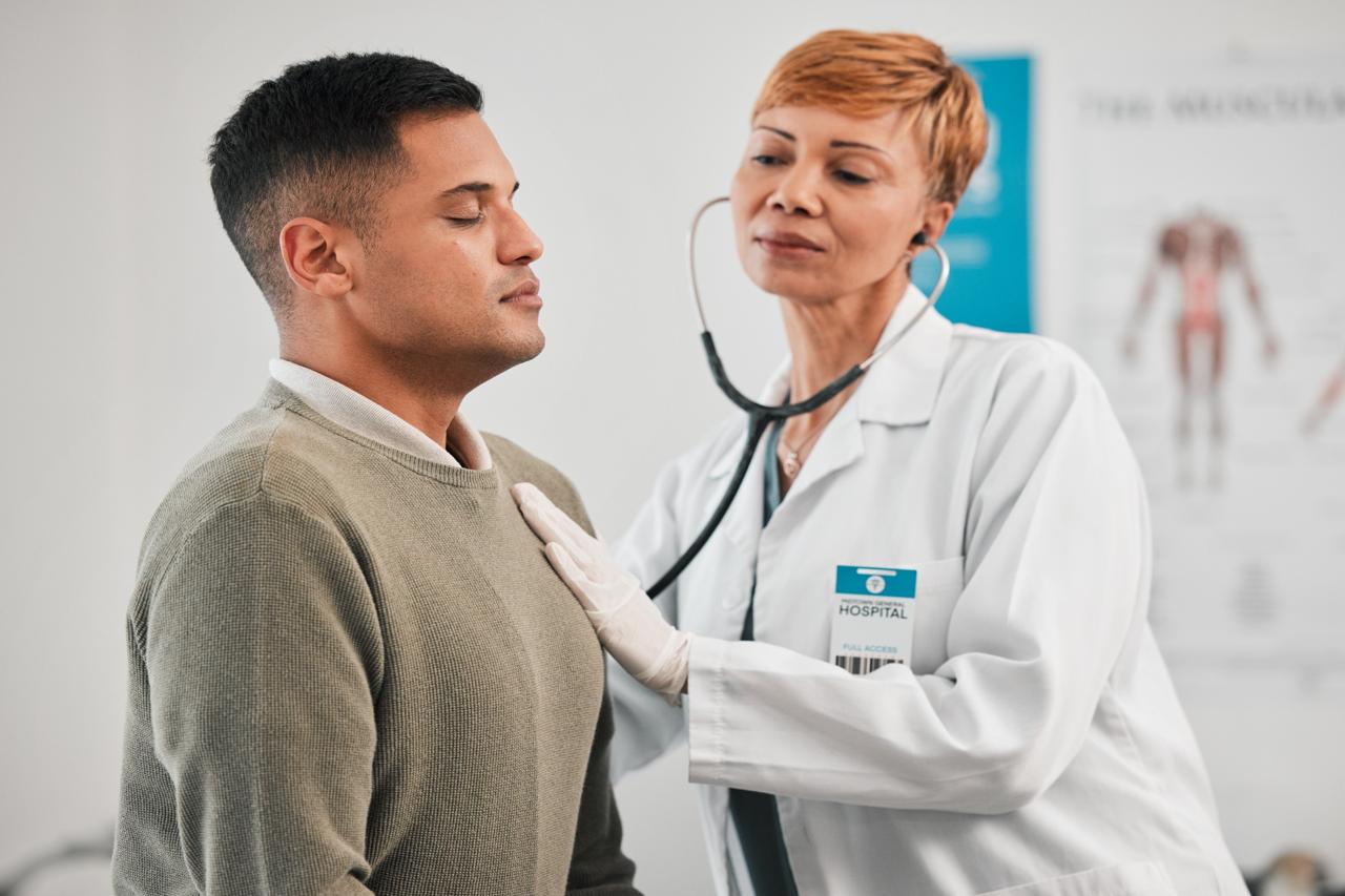 Doctor checking a male patient's lungs