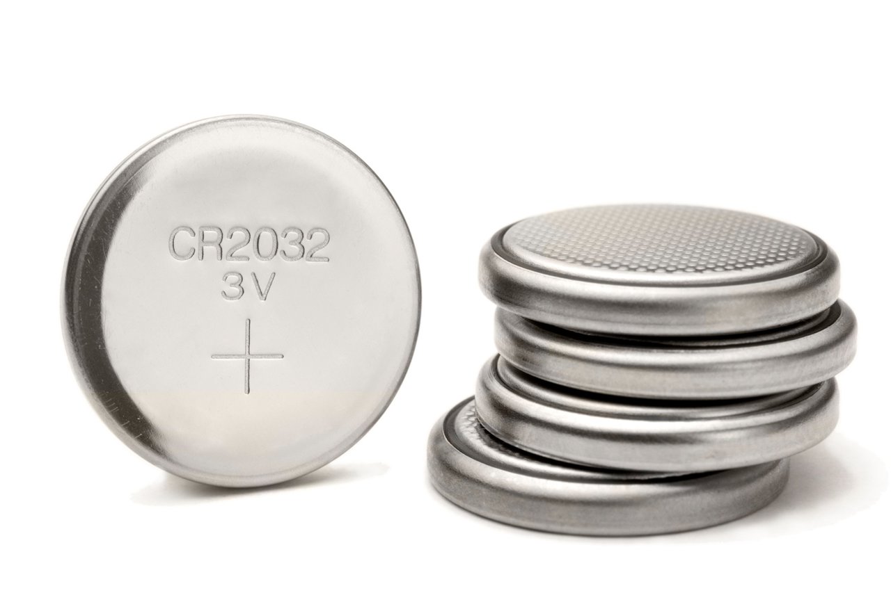 button cell battery with a stack of similar batteries beside it