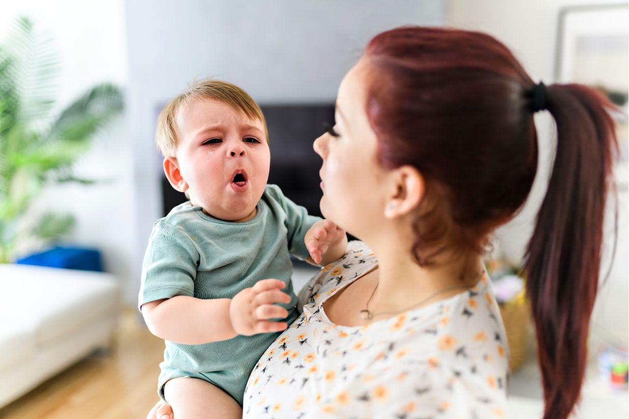 woman holding coughing baby