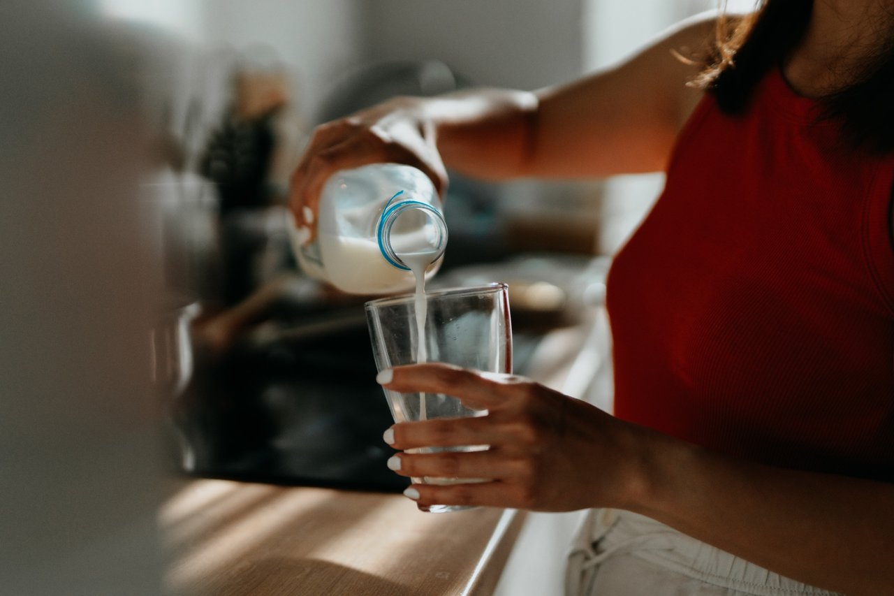 Woman pours milk into a glass