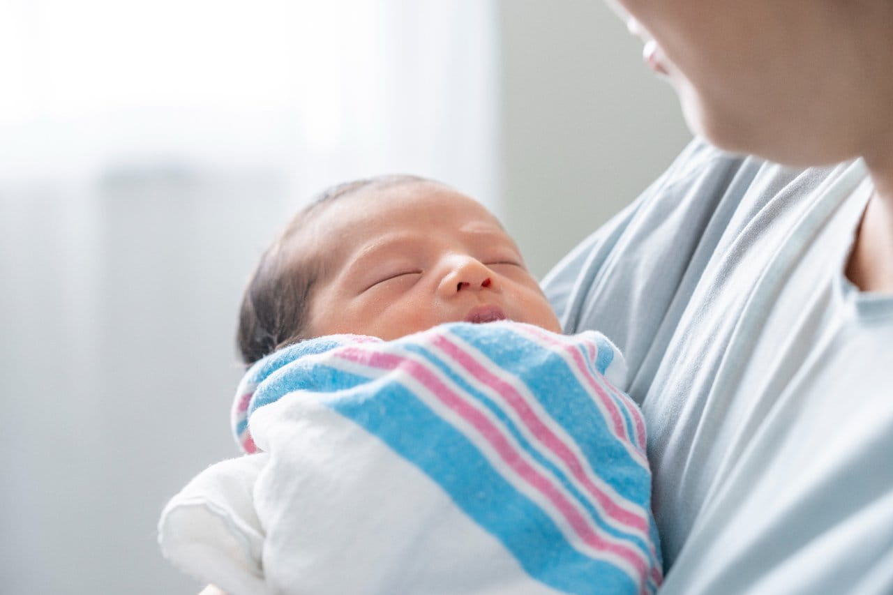 A mother holding a newborn.