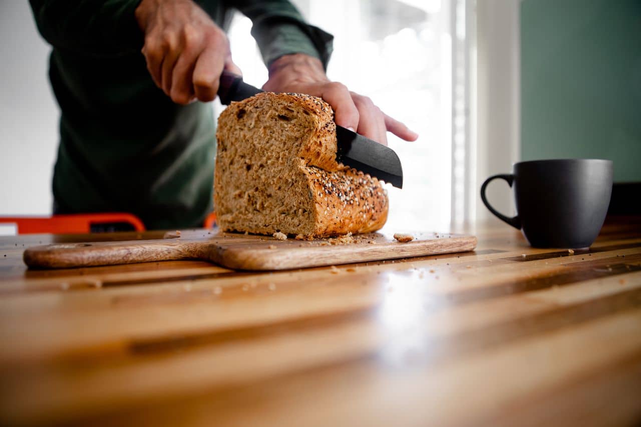 Man cutting whole wheat bread