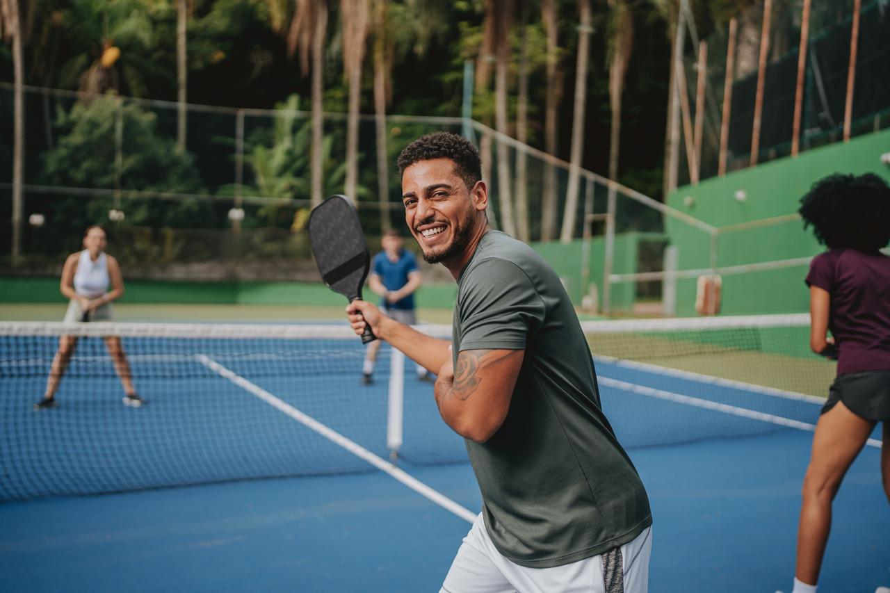 Man smiling and playing pickleball
