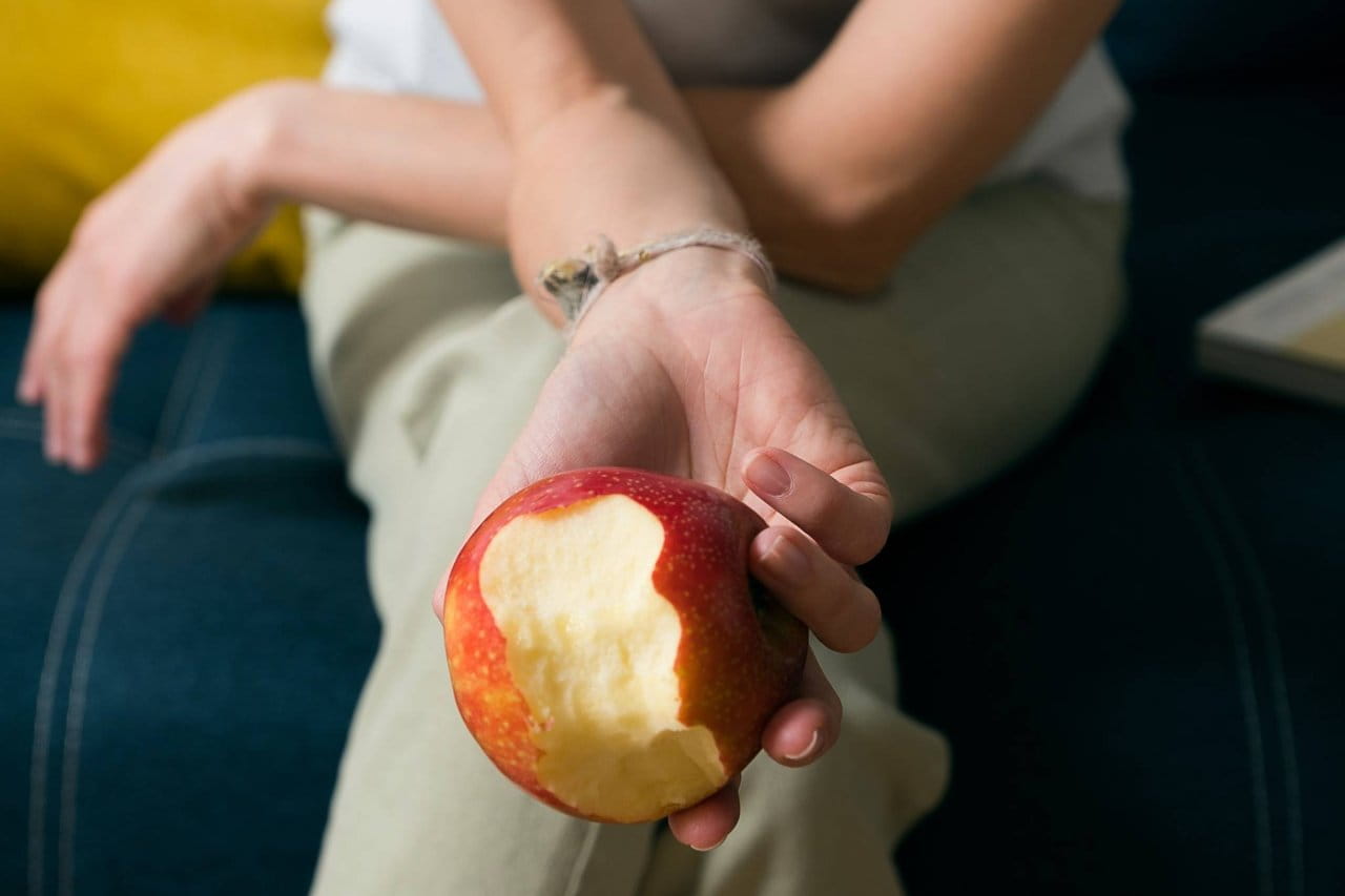 hand holding bitten apple