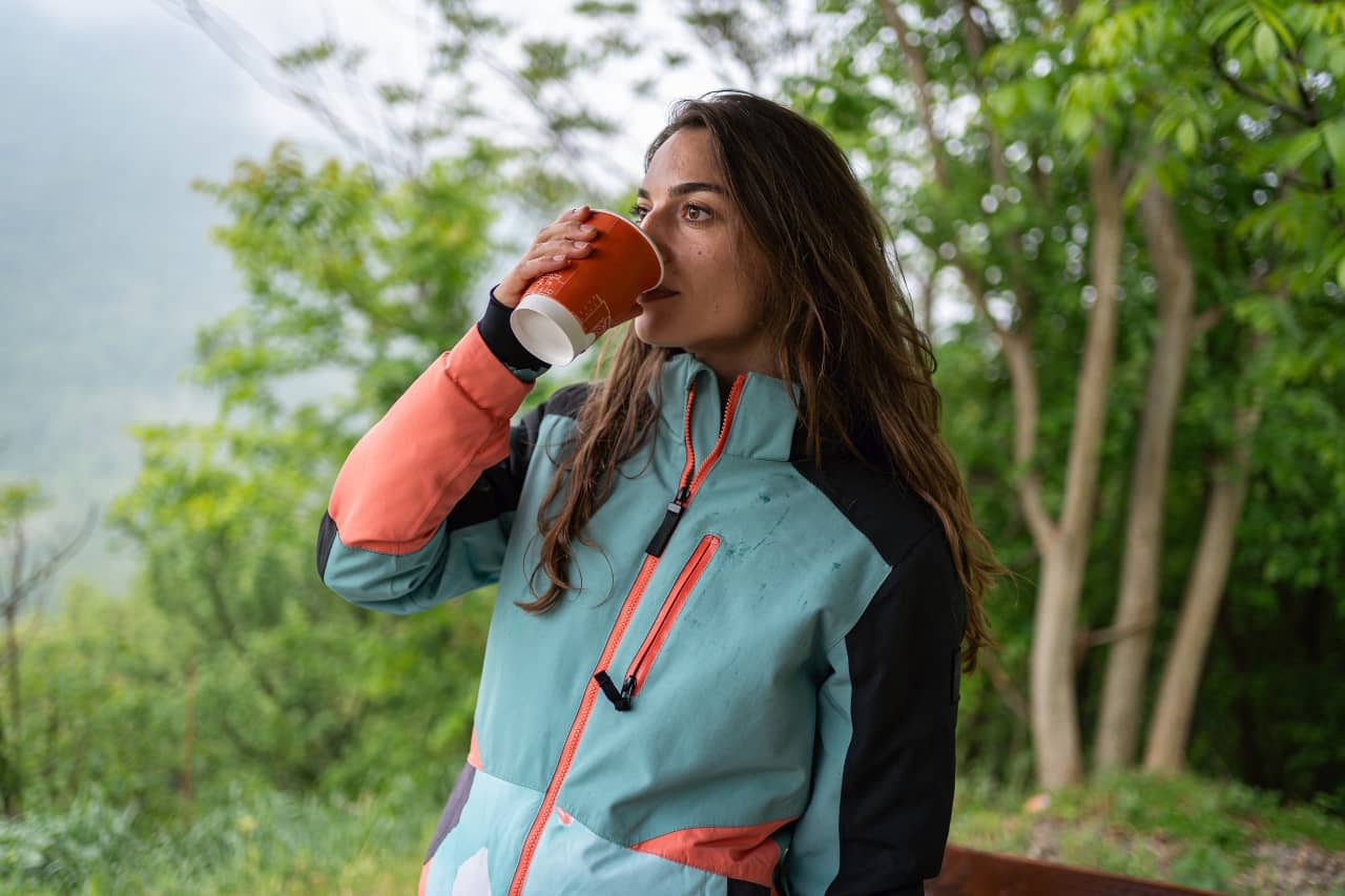 Woman drinking from a cup outdoors