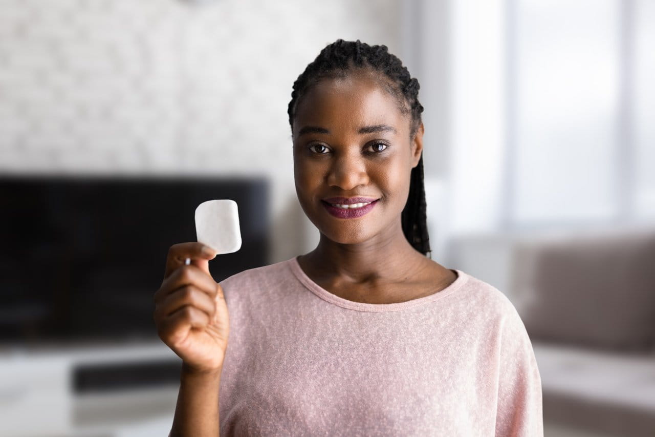 Woman holding up a GLP 1 Patch.