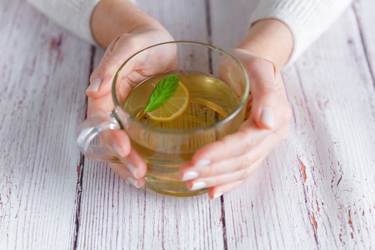 Hands holding herbal tea