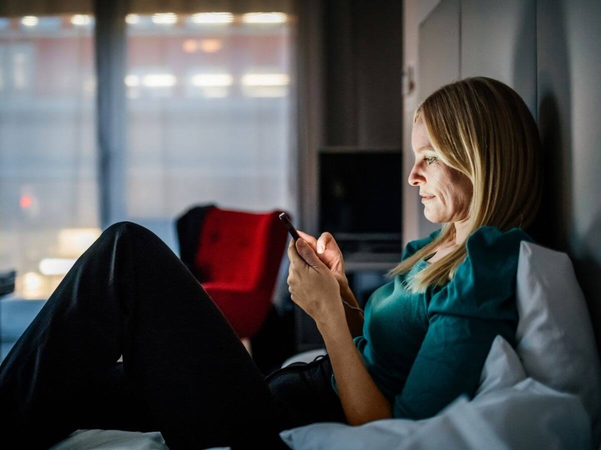 Woman scrolling on her phone at night in bed