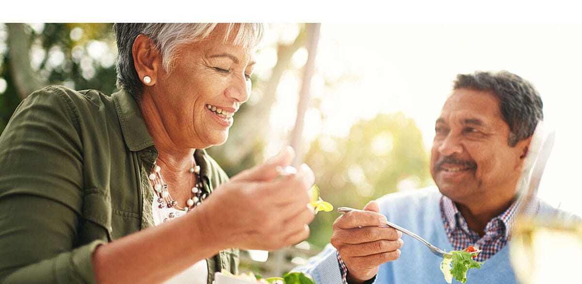 Smiling couple eating salad