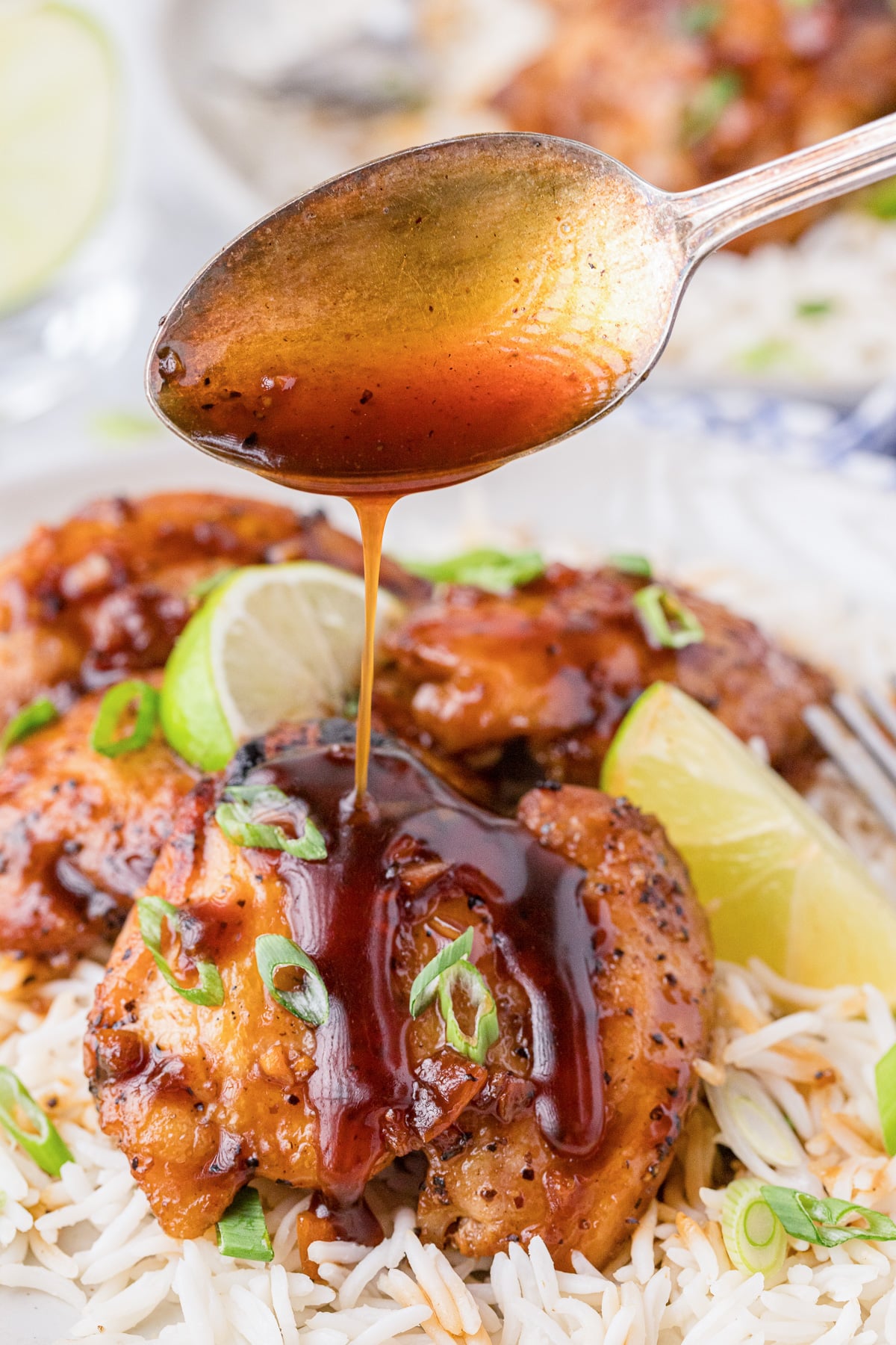 Filipino adobo chicken with spoon and sauce.