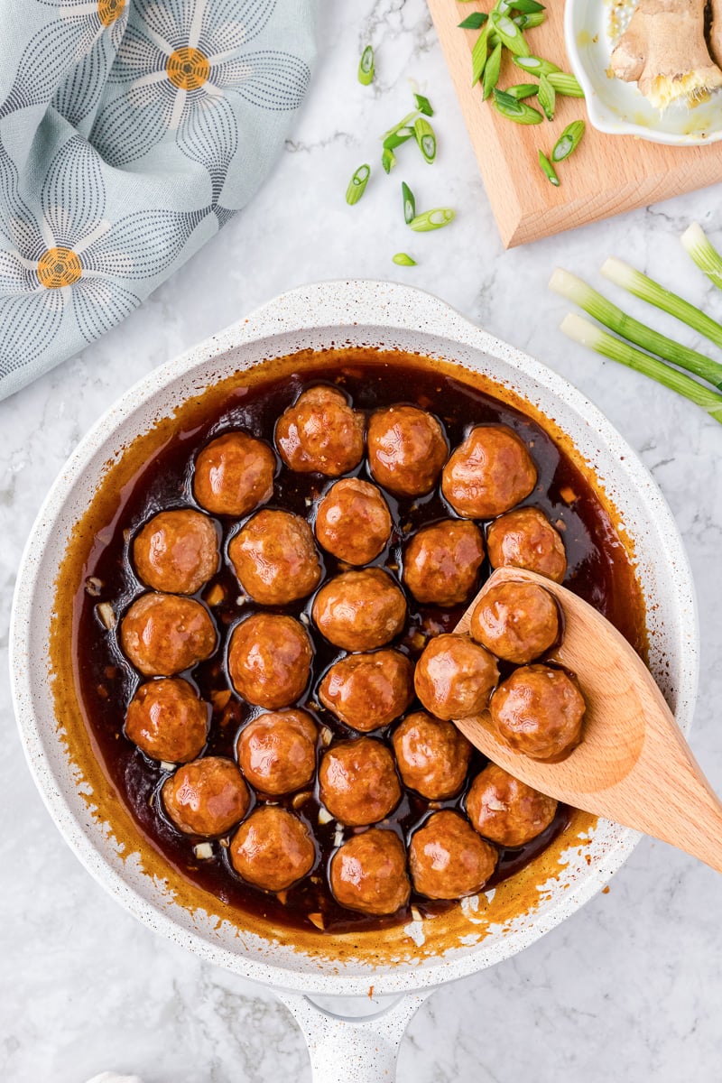 Meatballs simmering in honey sriracha sauce