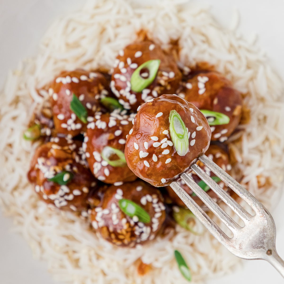 honey sriracha meatballs with fork over rice