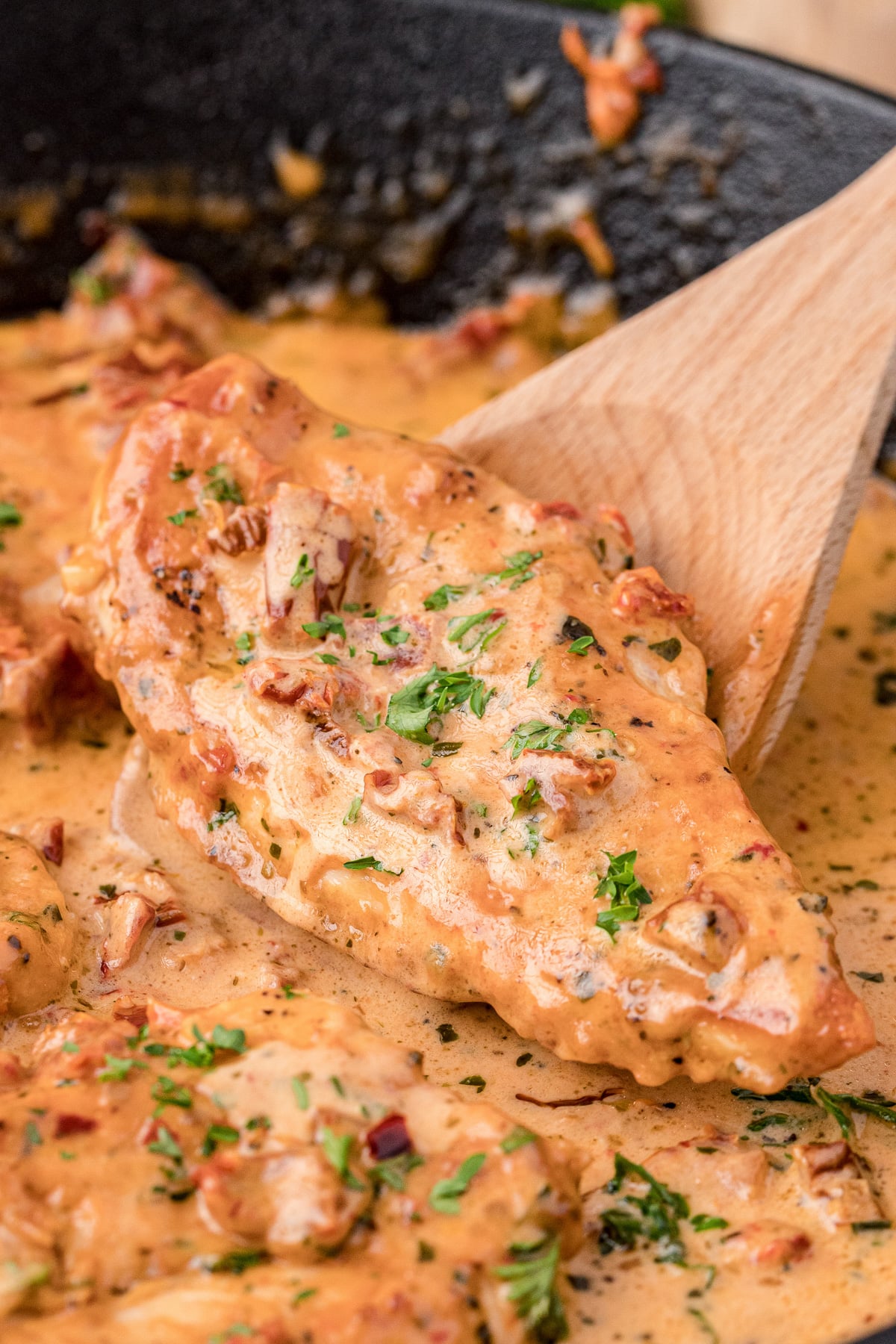 Marry me chicken in skillet with spoon.