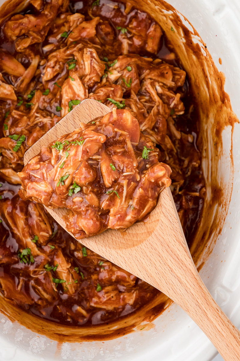 BBQ crockpot chicken with spoon.