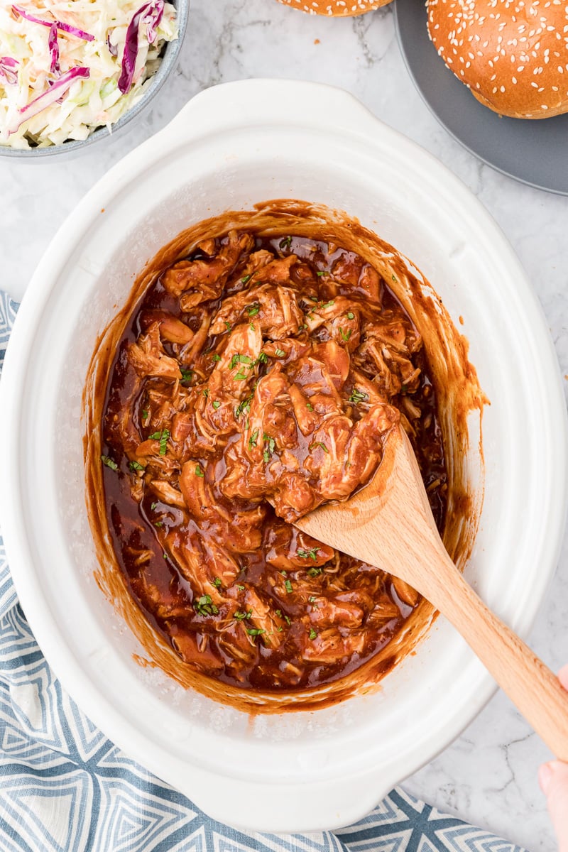 bbq crockpot chicken in white crockpot.