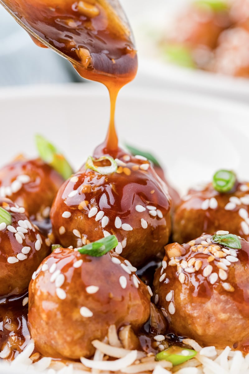 Honey sriracha meatballs with spoon drizzling sauce