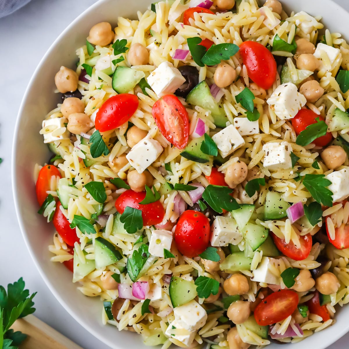 Orzo pasta salad in white bowl.