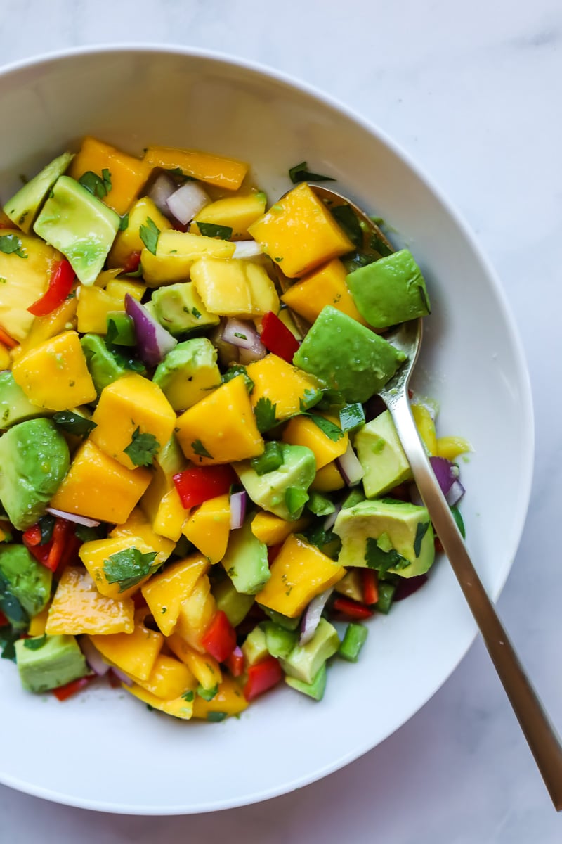Mango avocado salad in a white bowl.