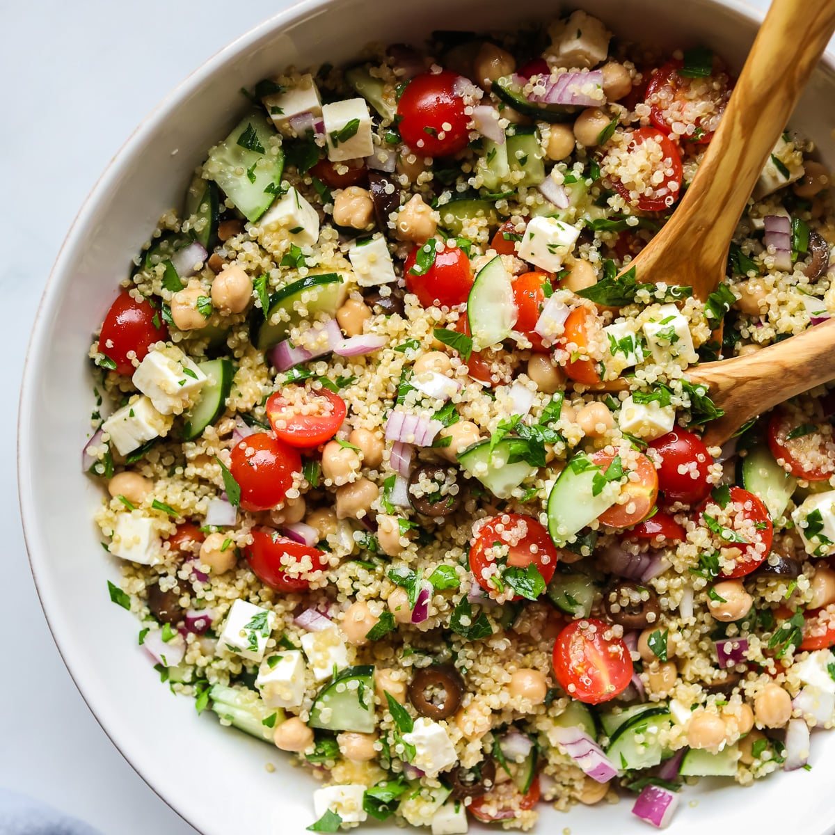 Mediterranean quinoa salad in white bowl.