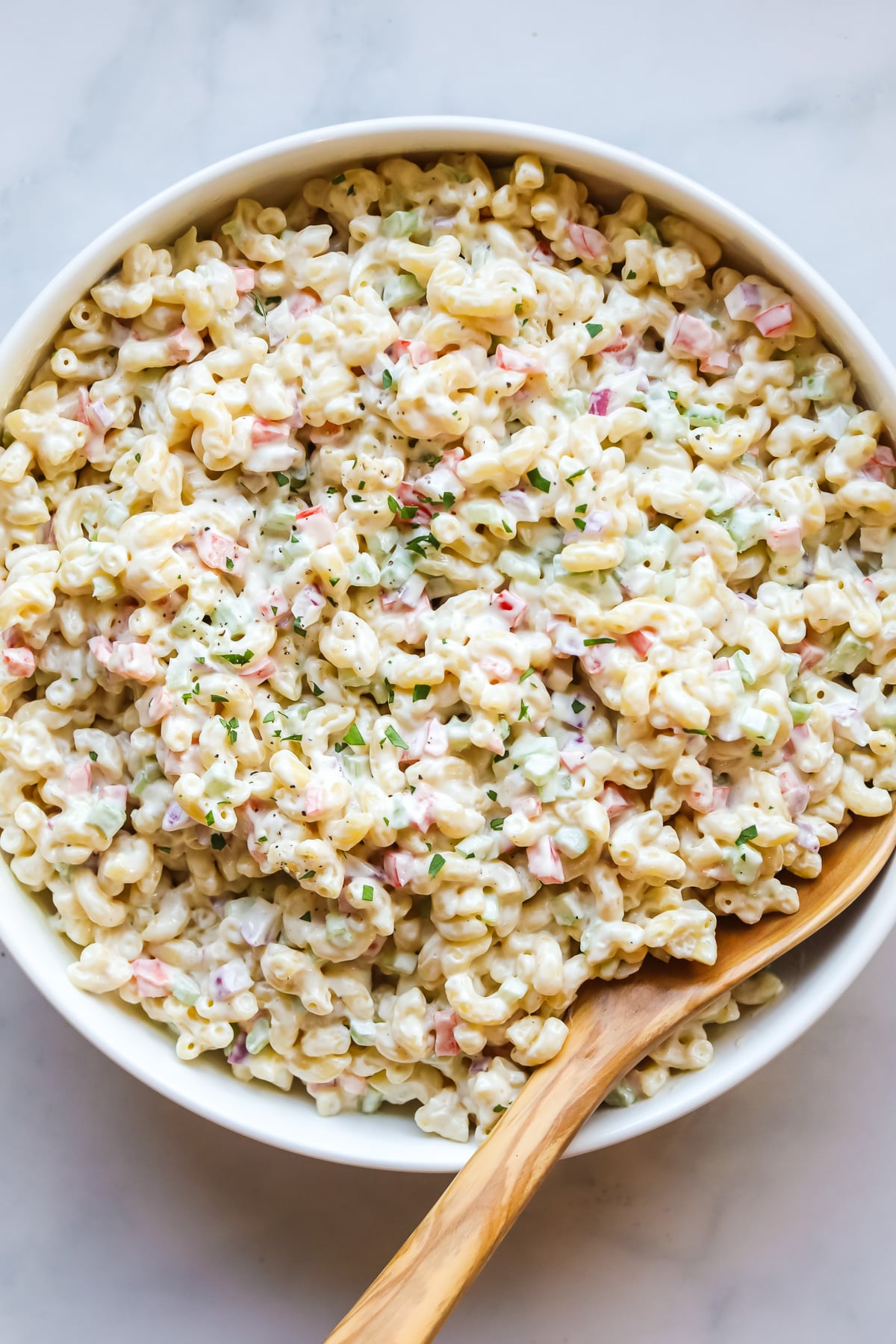 Macaroni salad in white bowl.