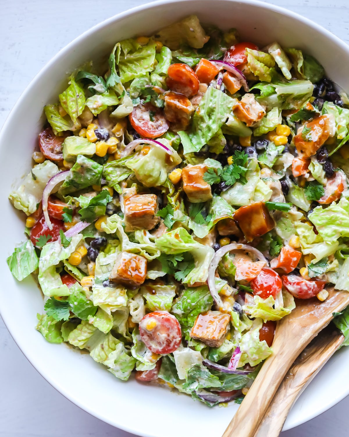 BBQ chicken salad in white bowl.