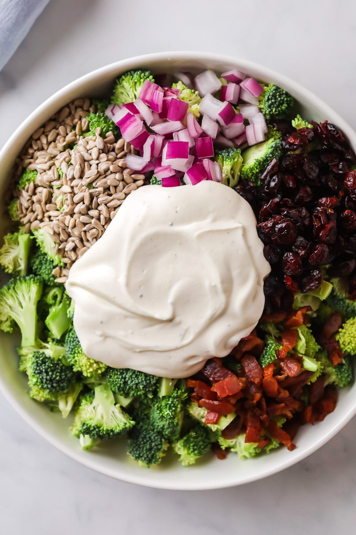 Broccoli salad with no mayo yogurt dressing on top.