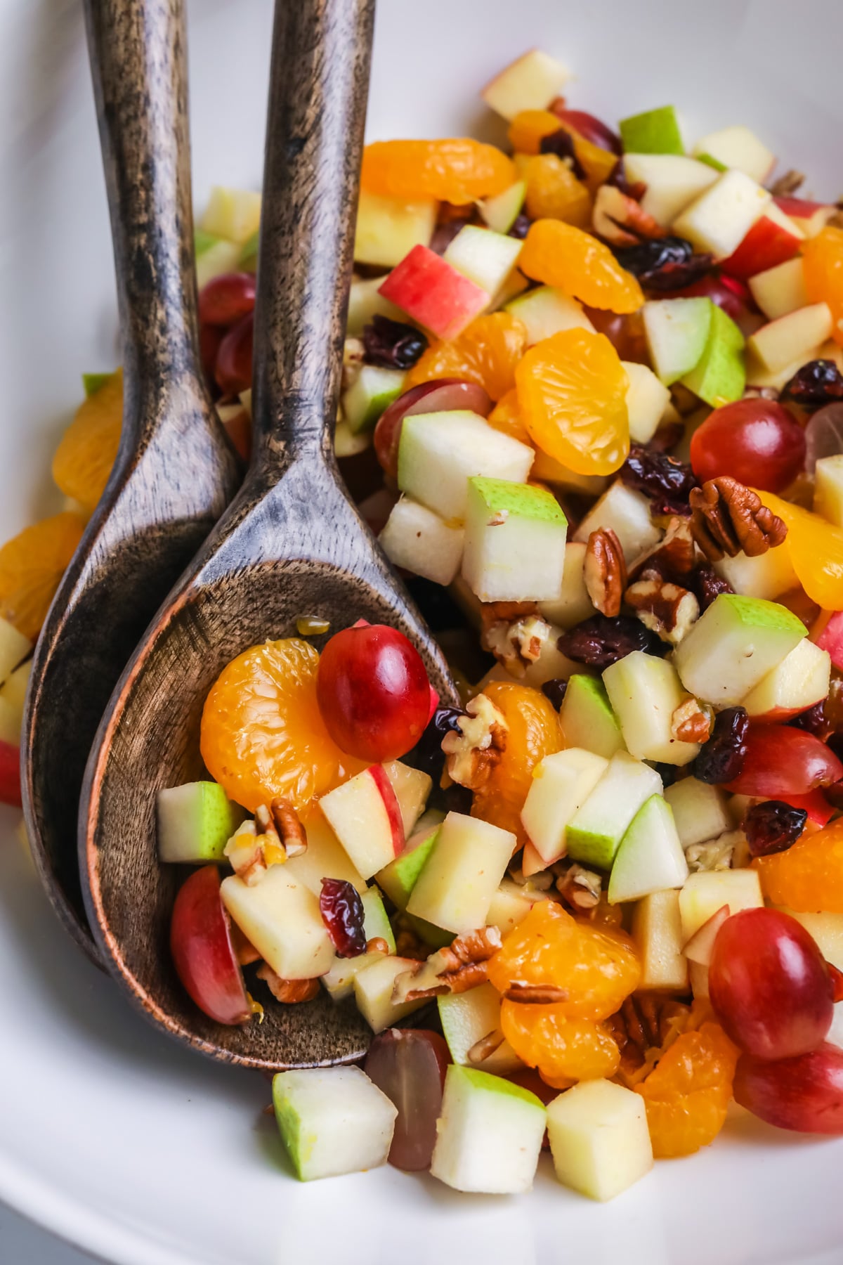 Thanksgiving fruit salad with wooden spoon.
