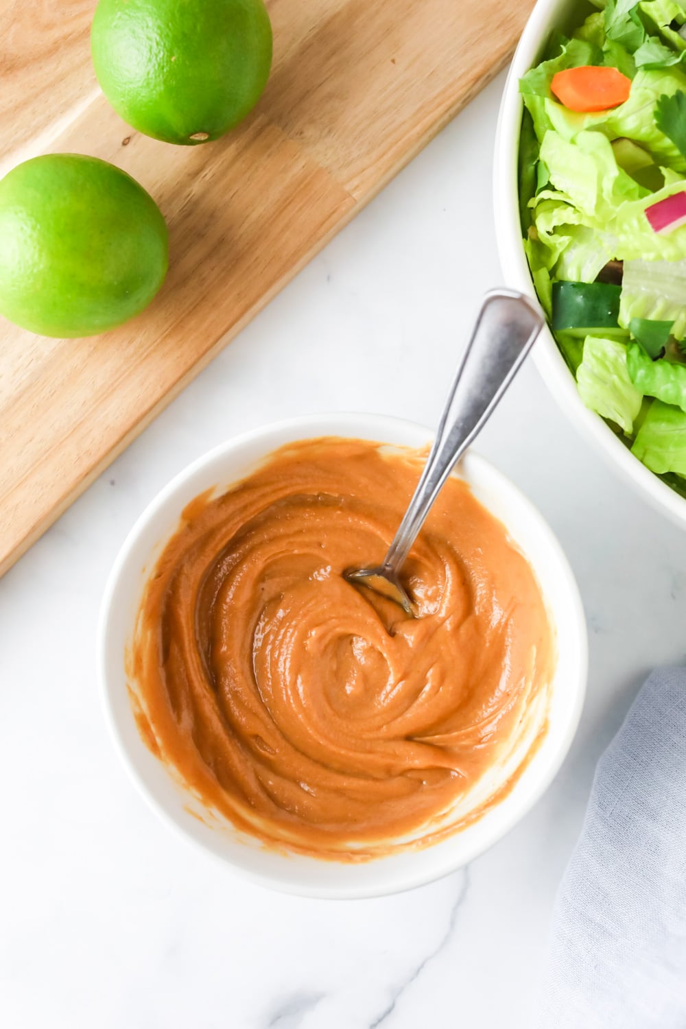 Mixing peanut salad dressing in a bowl.