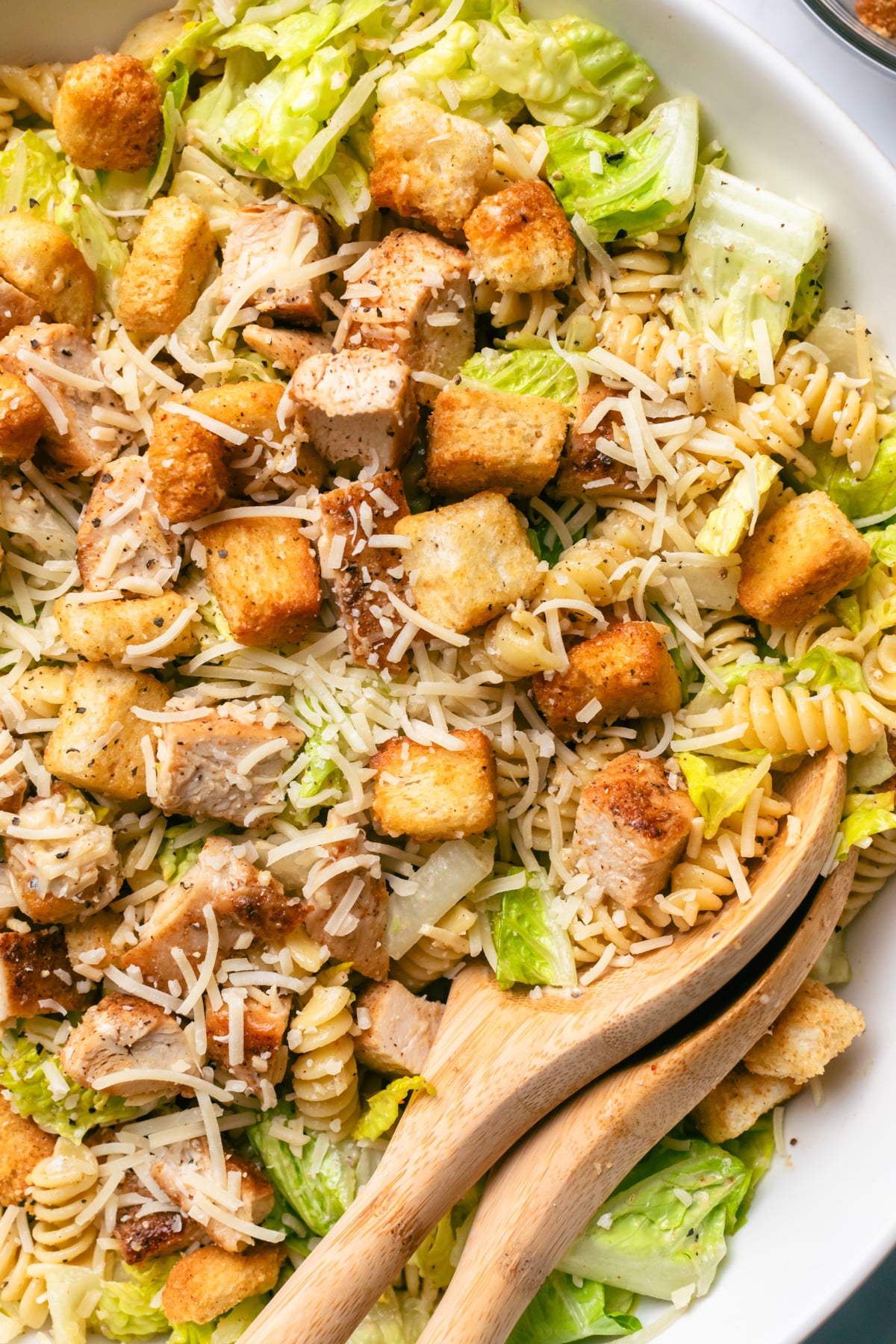 Chicken caesar salad with spoon.